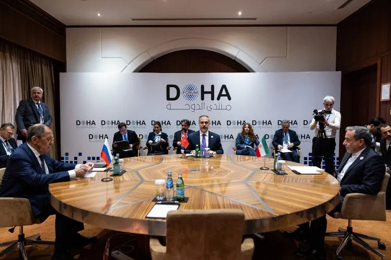 وزراء خارجية إيران عباس عراقجي (يمين) وتركيا هاكان فيدان (وسط) وروسيا سيرغي لافروف أثناء اجتماعهم لمناقشة الشأن السوري أمس أثناء منتدى الدوحة (الفرنسية)