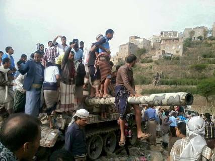 صورة : أهالي مشرعة وحدنان بتعز يلتقطون الصور على ظهر دبابة الإنقلابيين التي تم احراقها بالأمس