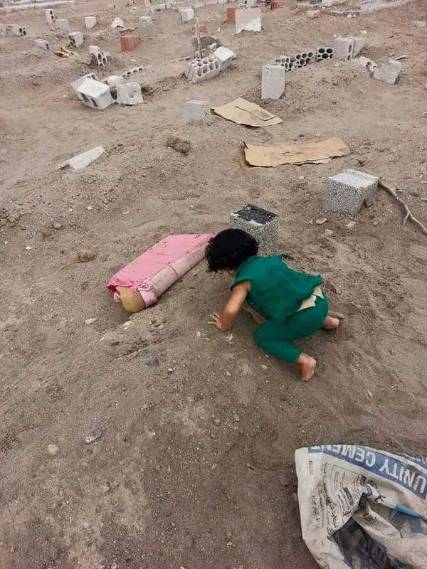 صورة مؤثرة لطفلة شهيد ترش قبر والدها وتحتضن قبره 